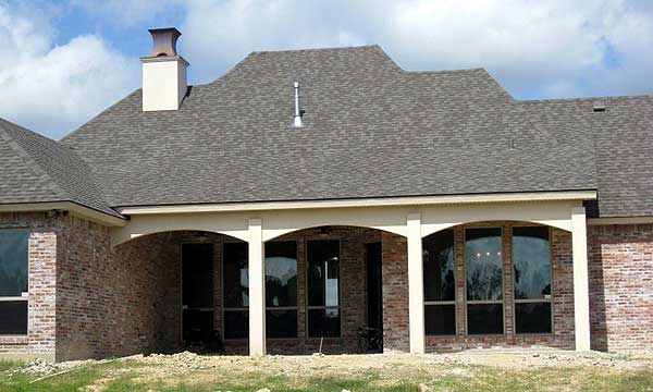 House plan exterior with brick facade, arched covered patio with columns, and multi-level rooflines.
