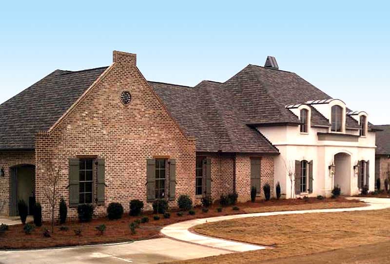 House plan exterior: Two-story brick home with pitched roof, dormers, gabled entry, and arched windows.