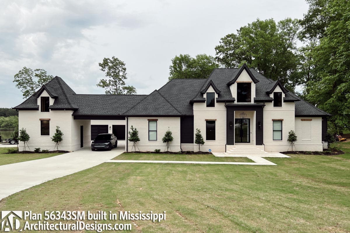 House plan exterior: Modern farmhouse style, white brick, black trim, dormers, steep gables, and a three-car garage.