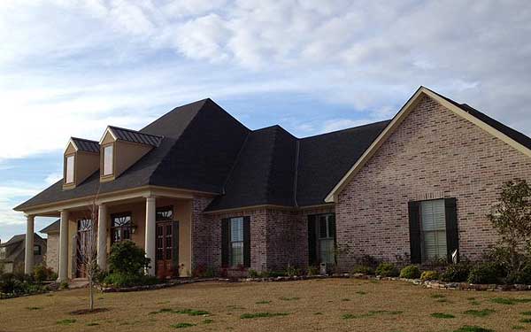 House plan exterior: Traditional style, two stories, brick facade, covered porch with columns, and dormer windows.