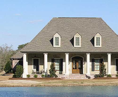 House plan exterior: two-story home with a full-width covered porch, Doric columns, and three front dormers.