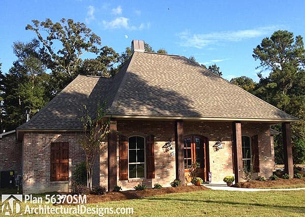 House plan exterior: Brick ranch with a covered front porch, visible gables, and dark wood shutters.