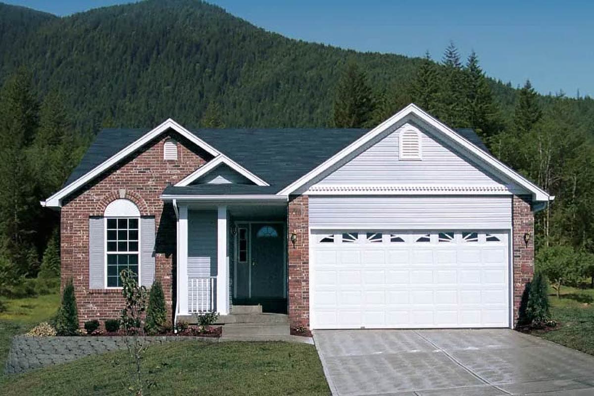 House plan exterior: One-story home with brick facade, prominent front gable, covered entry porch, and attached two-car garage.