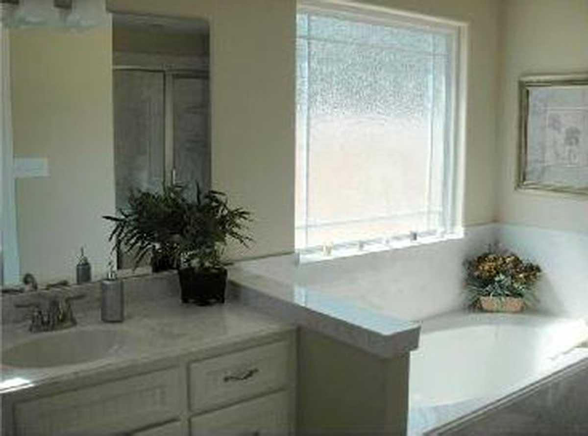 Bathroom with vanity, sink, and bathtub. Shower visible in background.
