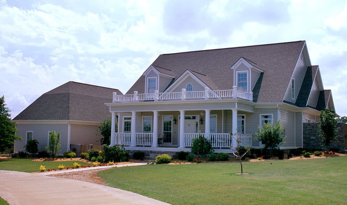 House plan exterior: Two-story home with wrap-around porch, columns, dormers, and second-story balcony.