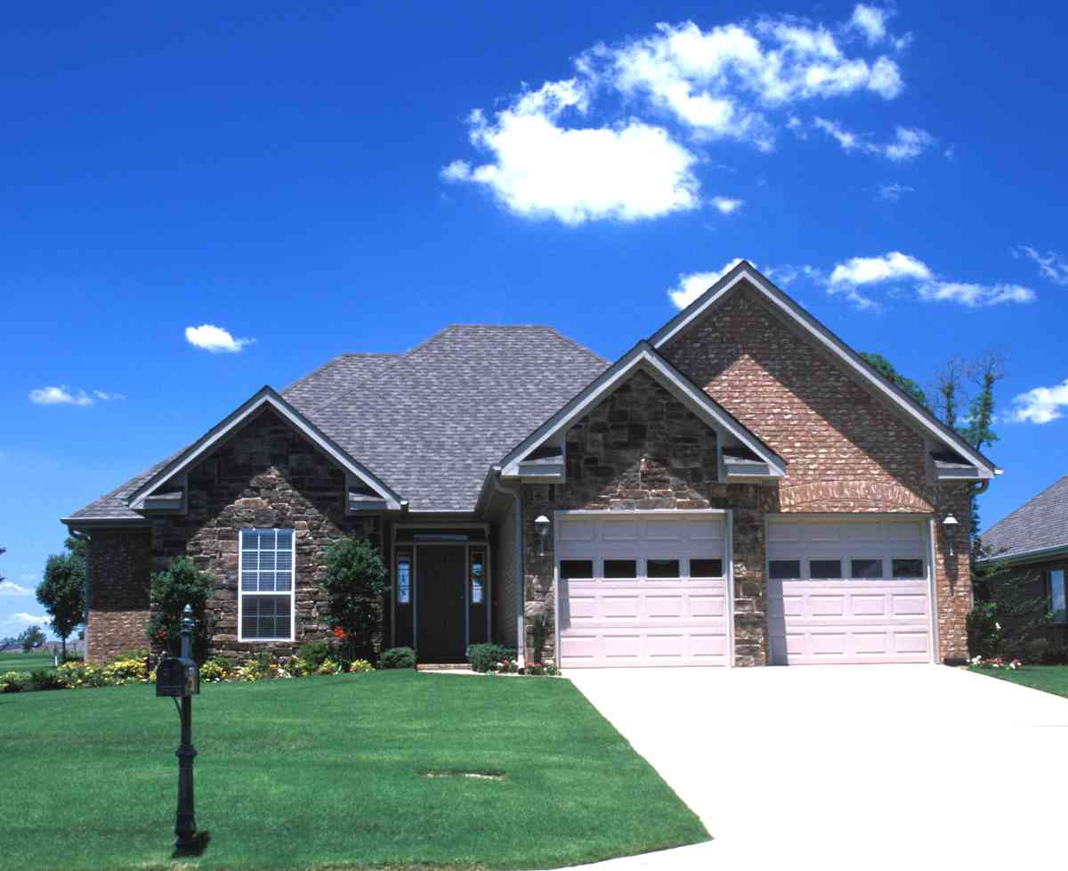 House plan exterior showing a single-story home with a combination of stone and brick, a prominent gable, and an attached three-car garage.