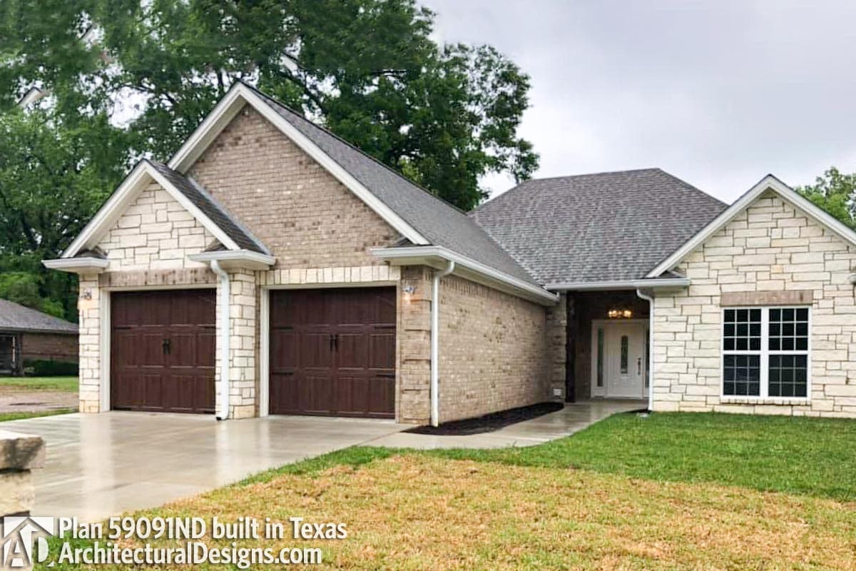 House plan exterior with two-car garage, brick and stone facade, and gabled rooflines.
