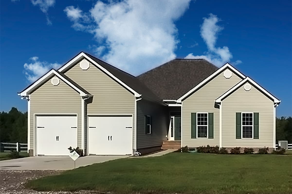 House plan exterior: One-story home with a symmetrical gable facade, two-car garage, and prominent central roofline.