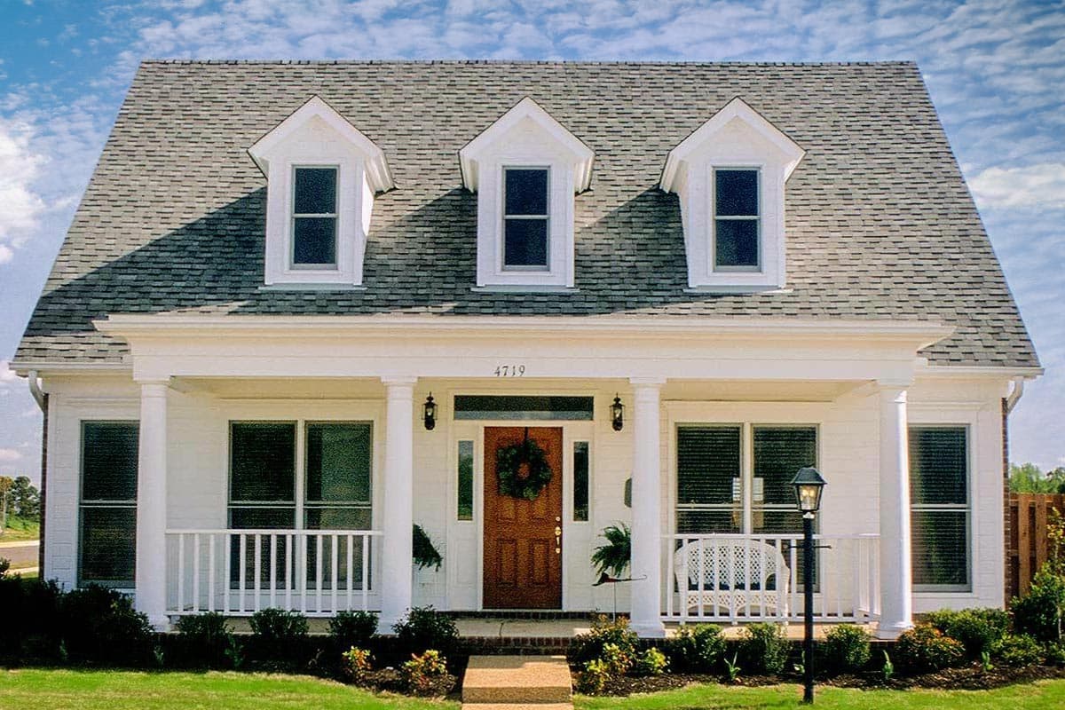 House plan exterior: A two-story home with a central gabled dormer and two side gabled dormers above a covered porch with columns.