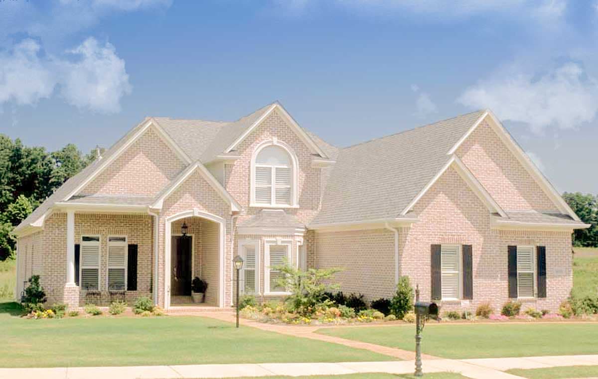 House plan exterior: Two-story brick home with arched entry, prominent gables, and bay window.