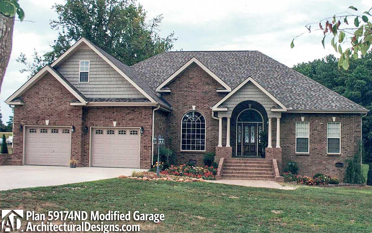 House plan exterior: Brick ranch with attached three-car garage, arched entry porch, and multiple gables.