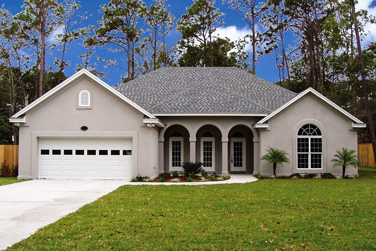 House plan exterior, one story, stucco finish, arched entry with columns, attached garage, gable roof with dormers.