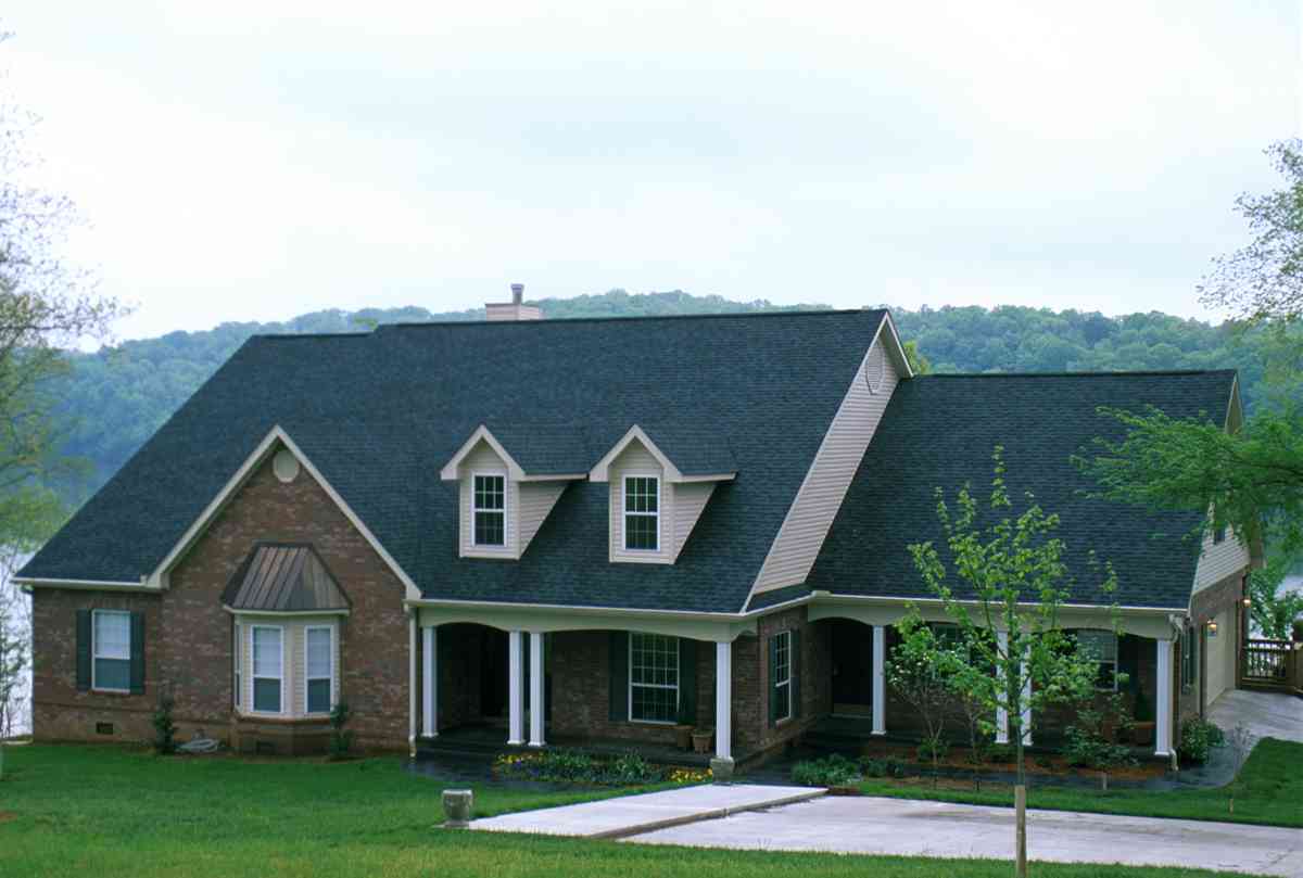 House plan exterior of a brick ranch with a covered porch, two dormers, and bay windows.