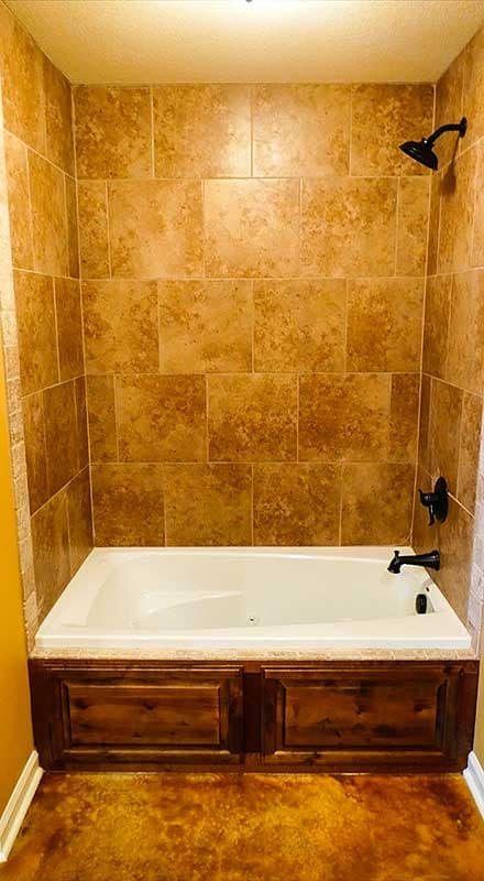 Bathroom with tiled shower walls, soaking tub, and dark wood paneled tub surround.