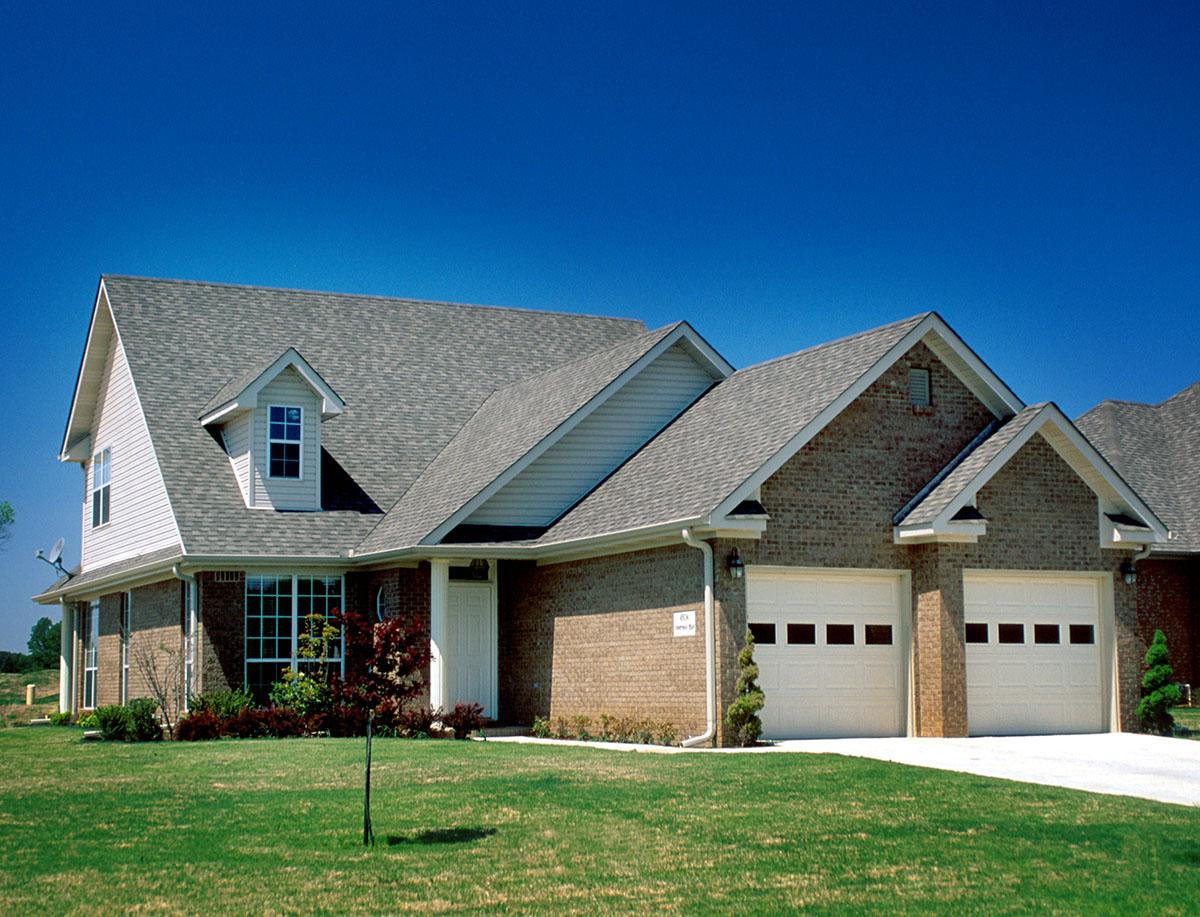 House plan exterior: Brick facade, side-entry double garage, gable dormer and varied rooflines. House plan.