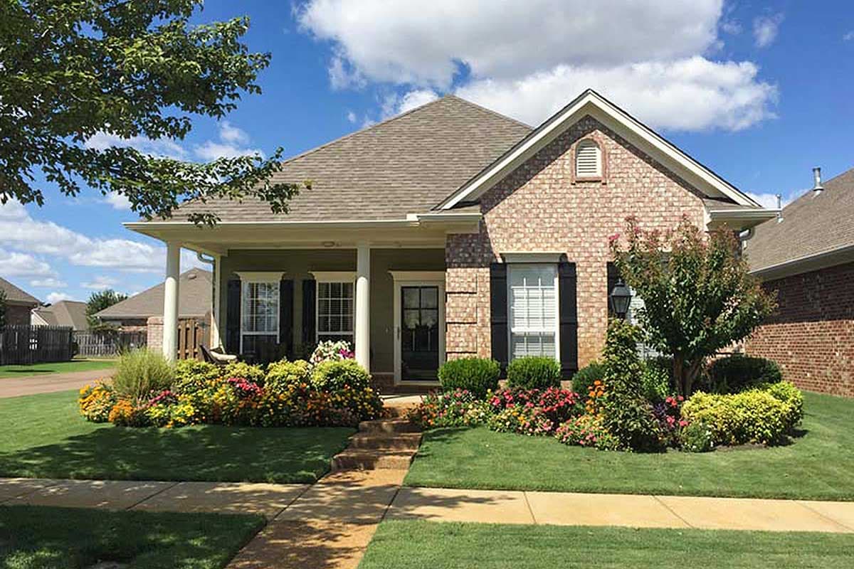 House plan exterior: One-story Modern Farmhouse with covered front porch, brick accents, dormer, and gabled rooflines.