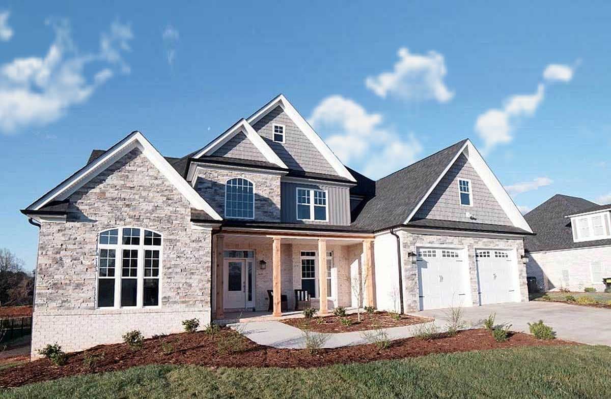 House plan exterior: Stone and siding facade, gabled rooflines, covered porch, and a three-car garage.