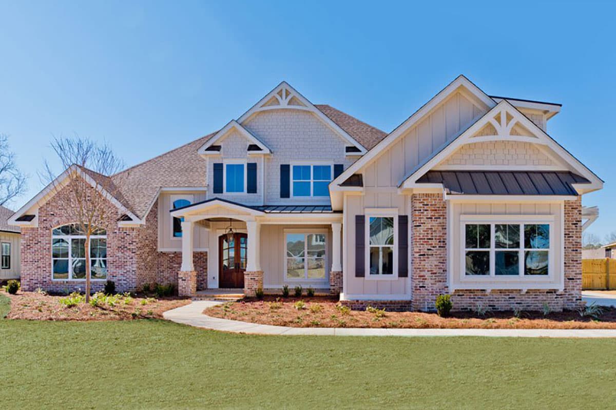 House plan exterior. Two-story Modern Farmhouse with gables, brick accents, and a covered porch. Features include a side-entry garage and dormers.