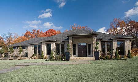 House plan exterior: Modern single-story home with stone facade, deep eaves, covered entry with double doors, and large windows.