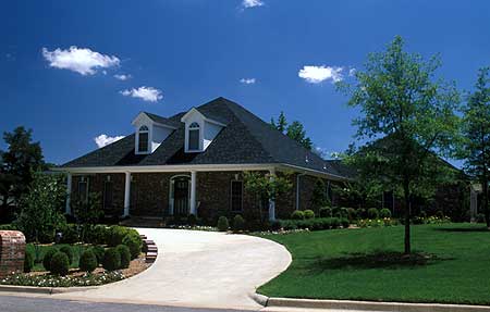 House plan exterior: brick facade, prominent dormers, and a covered front porch with columns.