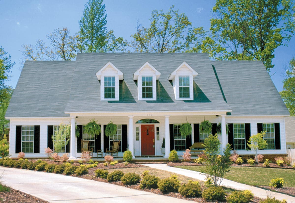 House plan exterior: Two-story home with a prominent covered porch, five dormer windows, and symmetrical window placement.