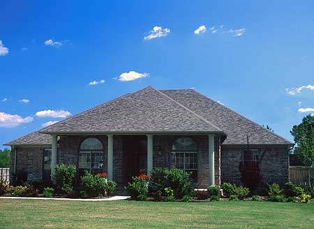 House plan exterior: Single-story brick home with a covered front porch, arched windows, and a gable roofline.
