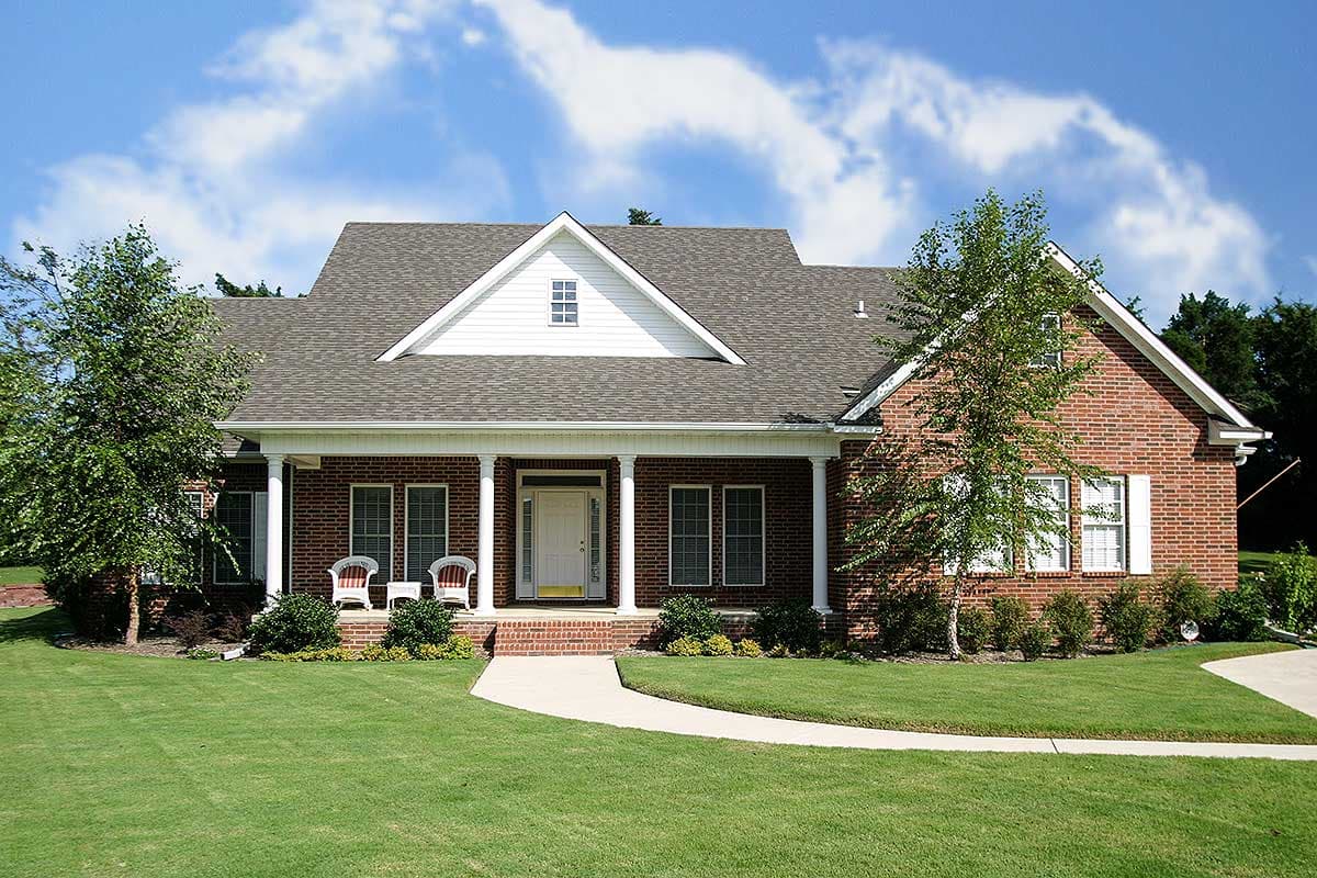House plan exterior of a one-story brick home with a covered front porch, gable dormer, and multi-pane windows.