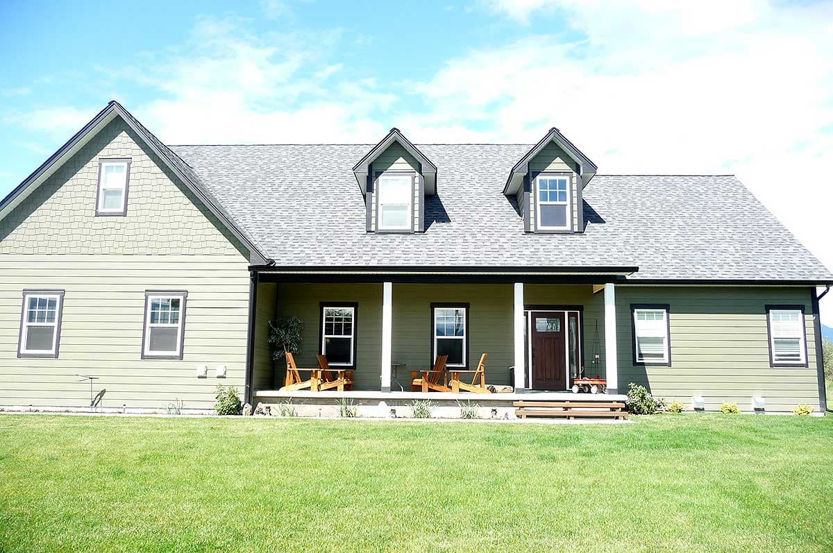 House plan exterior of a two-story Modern Farmhouse with a wrap-around porch, gables, and dormer windows.