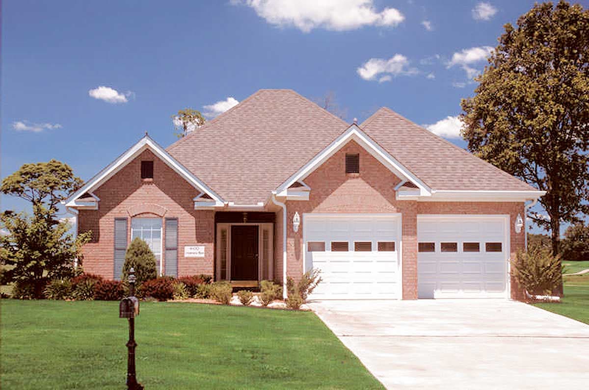 House plan exterior: One-story brick home with a prominent gable over the entrance, two-car garage with segmented doors, and a hip roof.