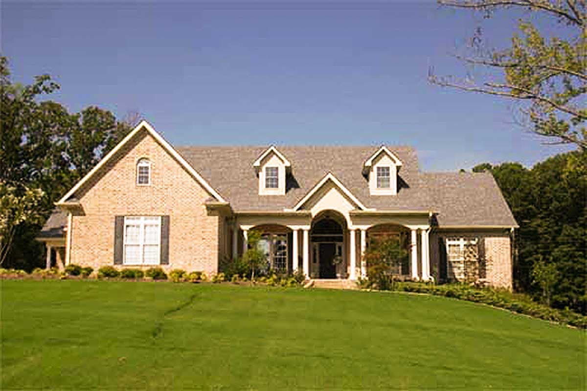 House plan exterior: Two-story brick home with a covered entryway, dormer windows, and a gable roofline.