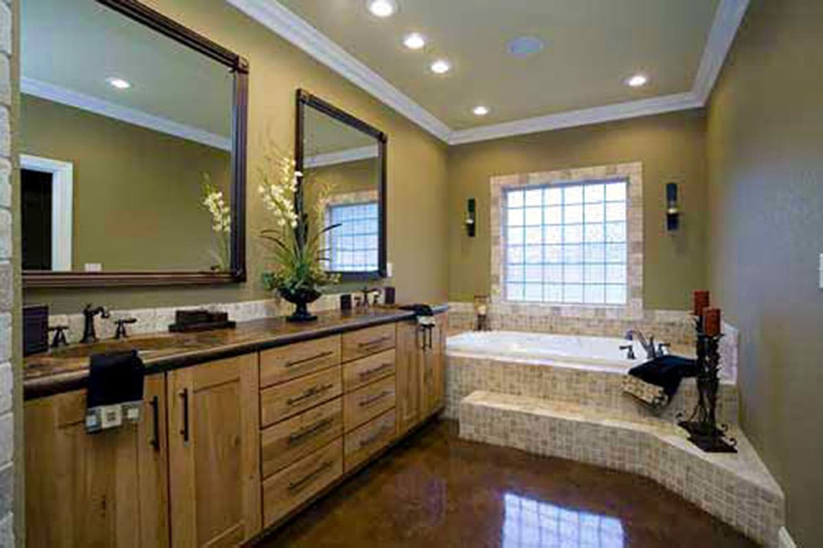 Bathroom with double vanity, jetted tub, and tiled step-up.