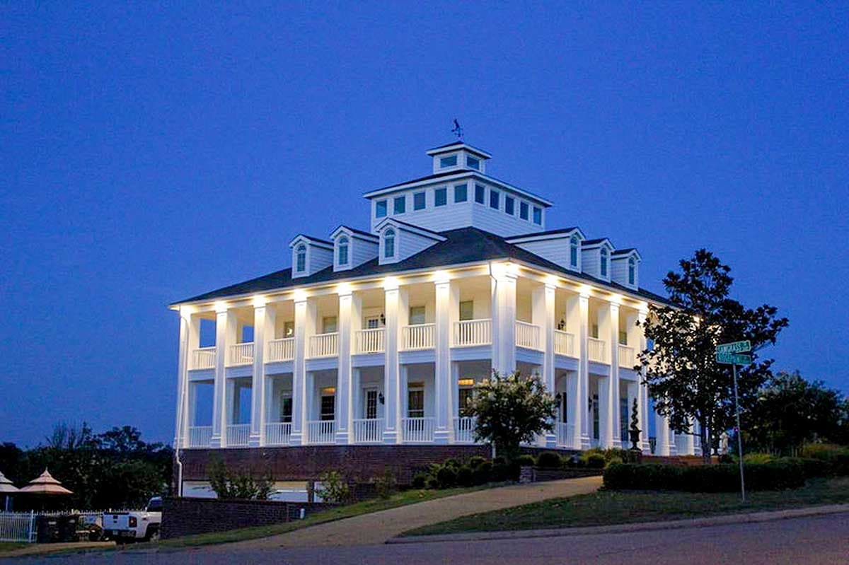 House plan exterior: Southern Colonial style, four stories, extensive wraparound porches with columns, dormers, and cupola.