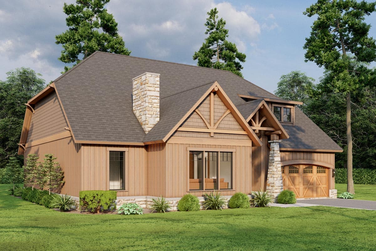 House plan exterior: Timber frame accents, stone chimney, arched garage door, dormer window, and steeply pitched rooflines.