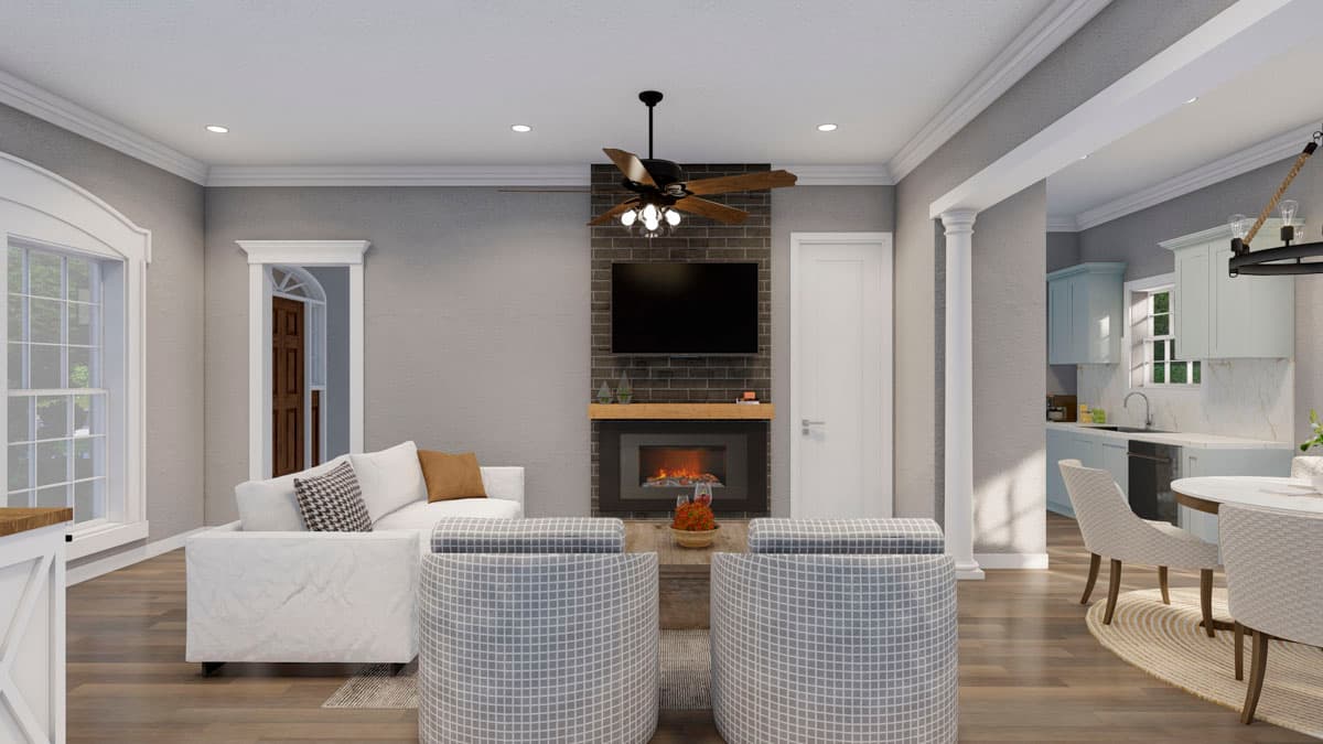 Interior rendering of a great room with fireplace, mounted TV, white sofa, accent chairs, and adjacent kitchen with light blue cabinets.