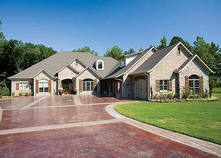 House plan exterior with brick facade, multiple gables, dormer window, and a U-shaped driveway.