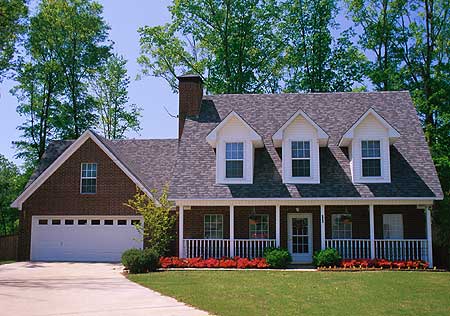 House plan exterior: Two-story brick home with a front porch, three dormers, and an attached garage.