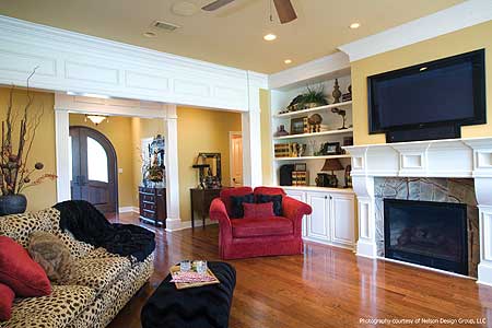 Living room with fireplace, built-in shelves, and arched doorway to entryway.
