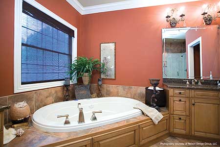 Master bathroom featuring an oval soaking tub, double vanity with granite countertop, and a separate glass-enclosed shower.