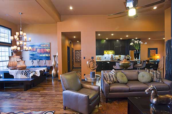 Open-concept living area with dining table, kitchen with dark cabinetry, and seating area with sofa and chairs.