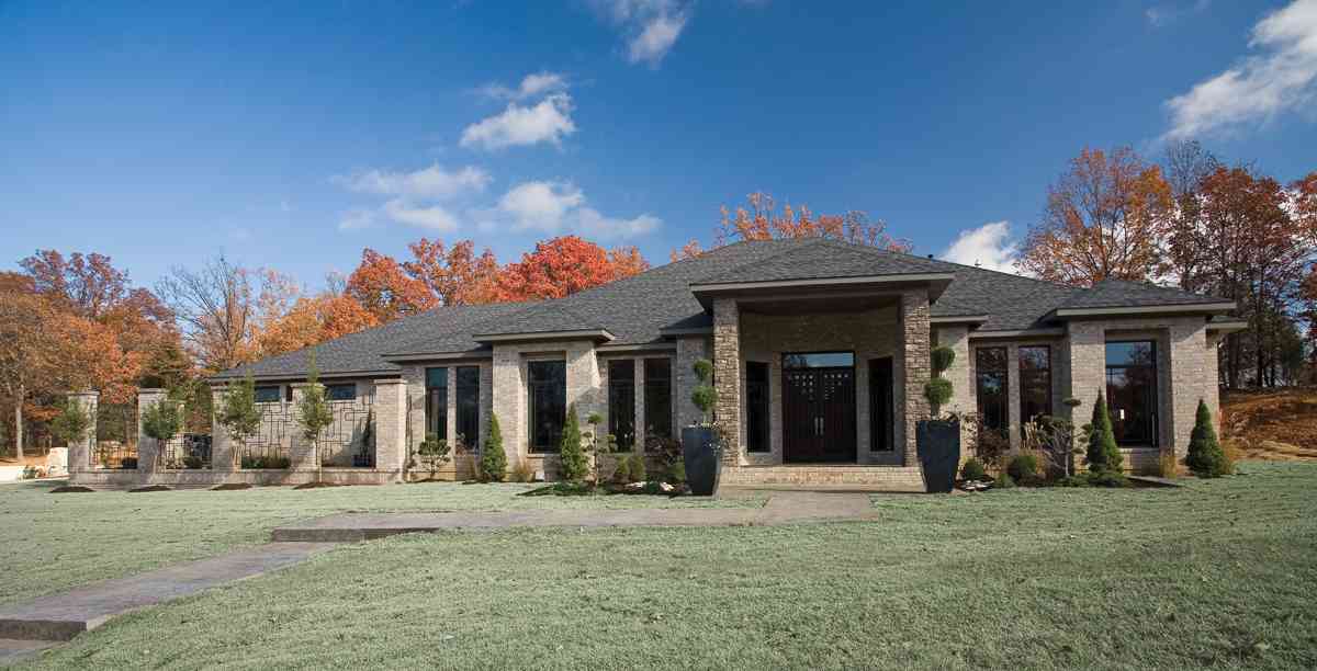 One-story house plan exterior with stone accents, a covered entryway, and large windows.