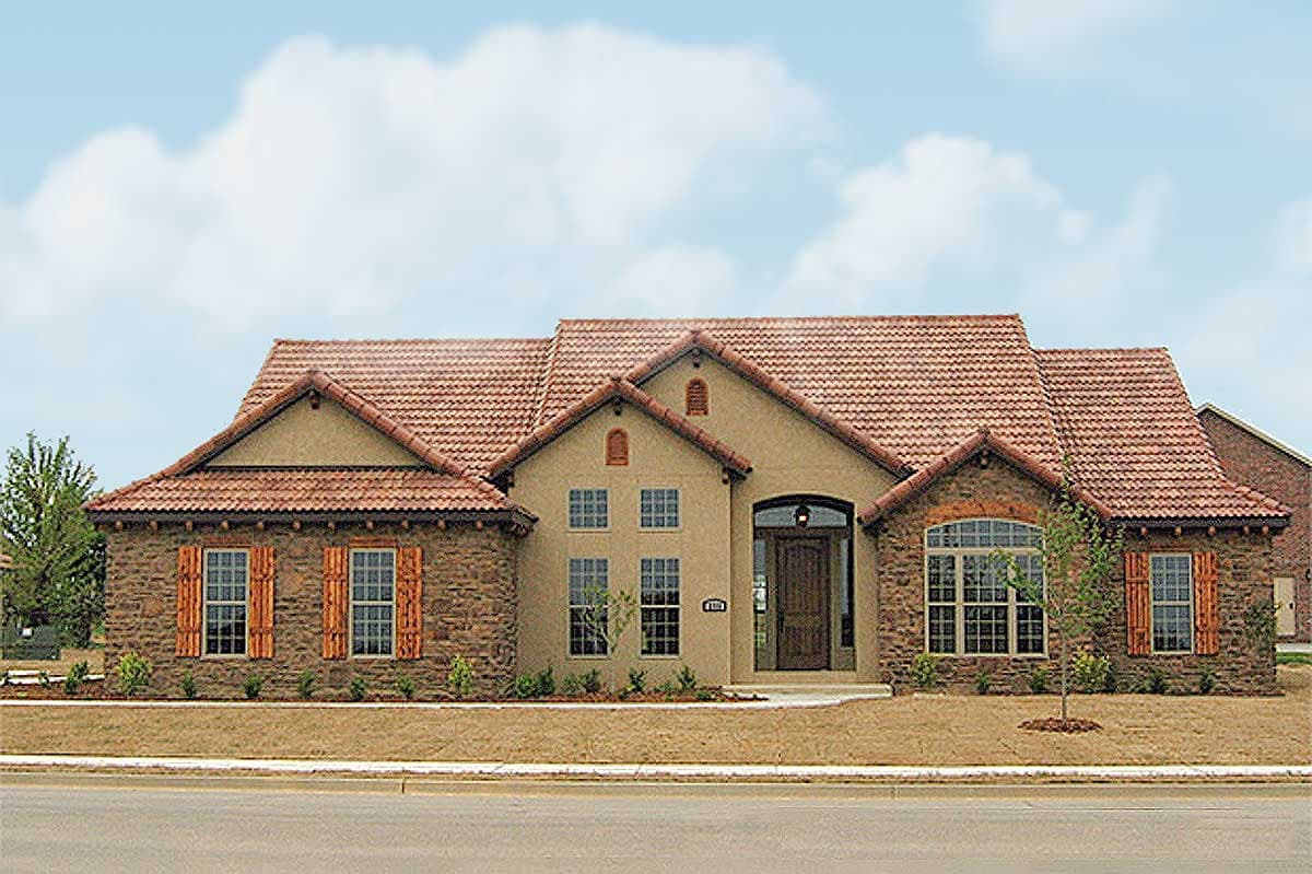House plan exterior with a Mediterranean architectural style, featuring a clay tile roof, stone accents, and arched windows.