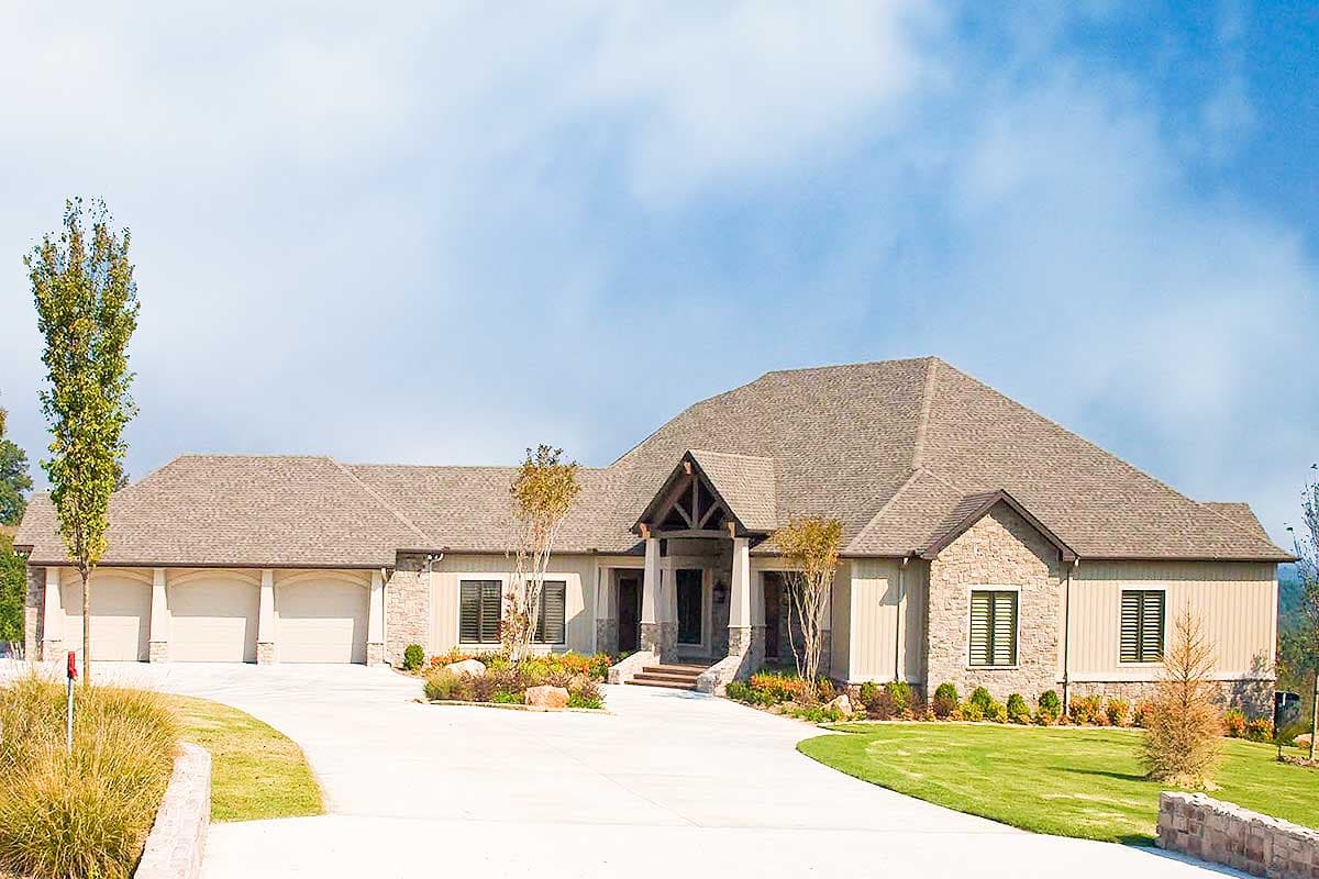 House plan exterior of a sprawling ranch with a stone and siding facade, triple garage, and a covered entry with exposed beams.