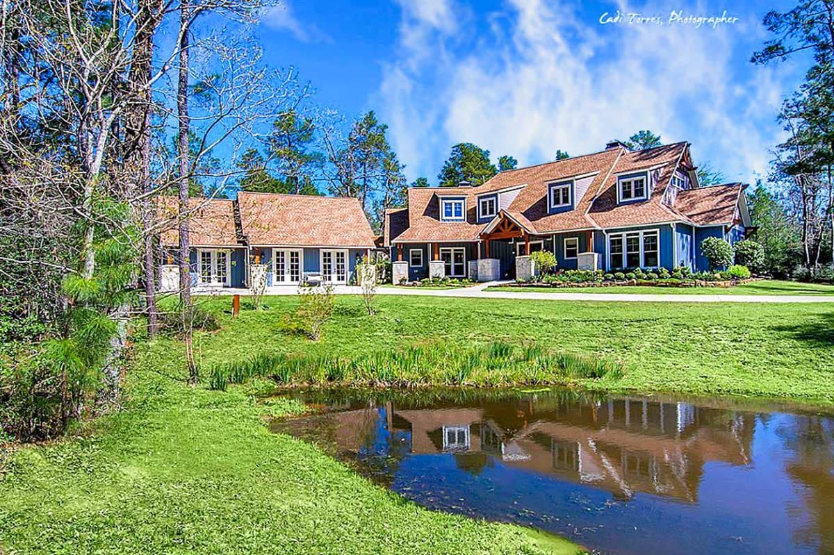 House plan exterior of a two-story blue home with a prominent gabled roof, dormers, and a covered entry.