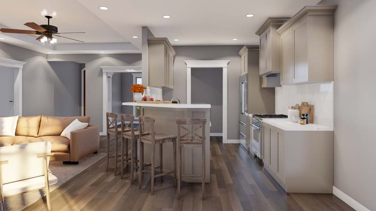 Open concept living space with kitchen island, bar seating, sofa, and ceiling fan.