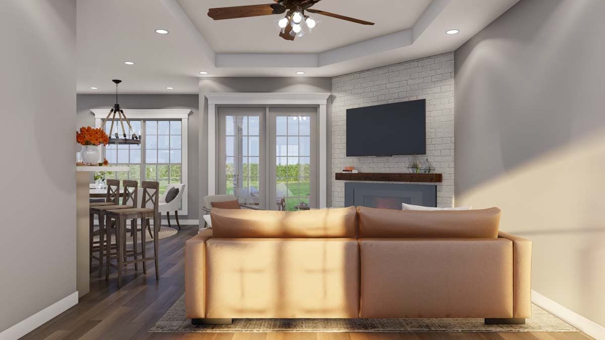 Living room with fireplace, vaulted ceiling, recessed lights, ceiling fan, and bar seating area.