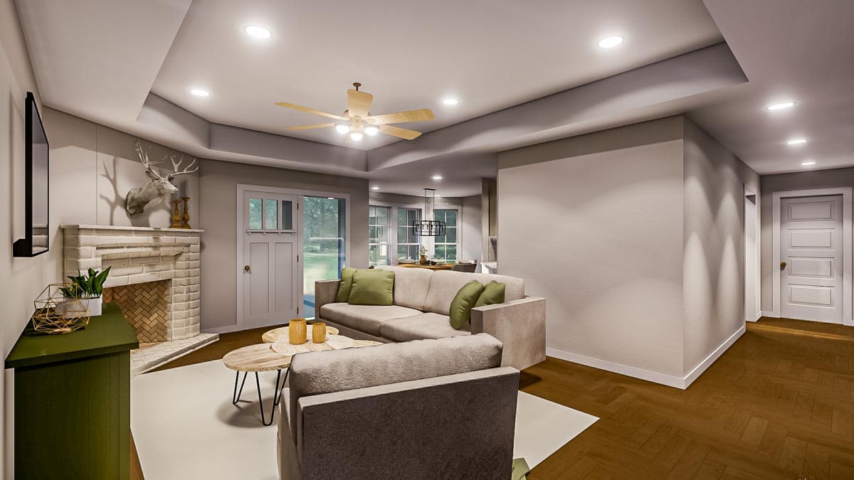 A modern living room featuring a fireplace with a mounted deer head, a neutral-toned sectional sofa, and a ceiling fan.