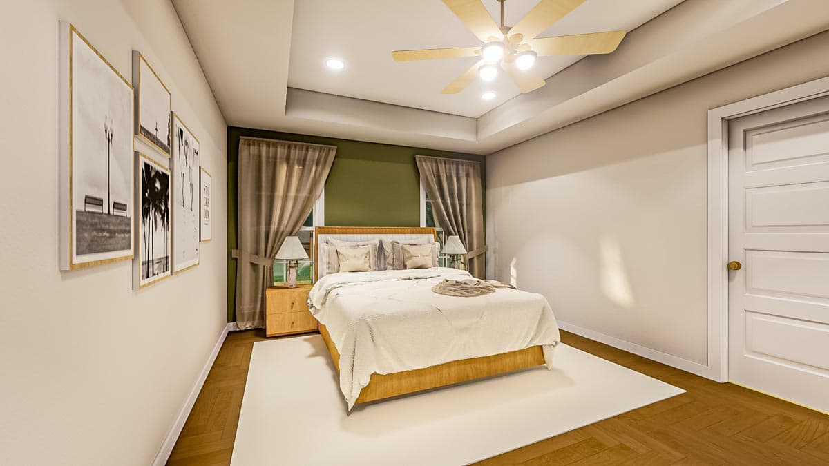 Spacious bedroom with a large bed, nightstands with lamps, and framed artwork on the wall. A ceiling fan hangs above the bed.