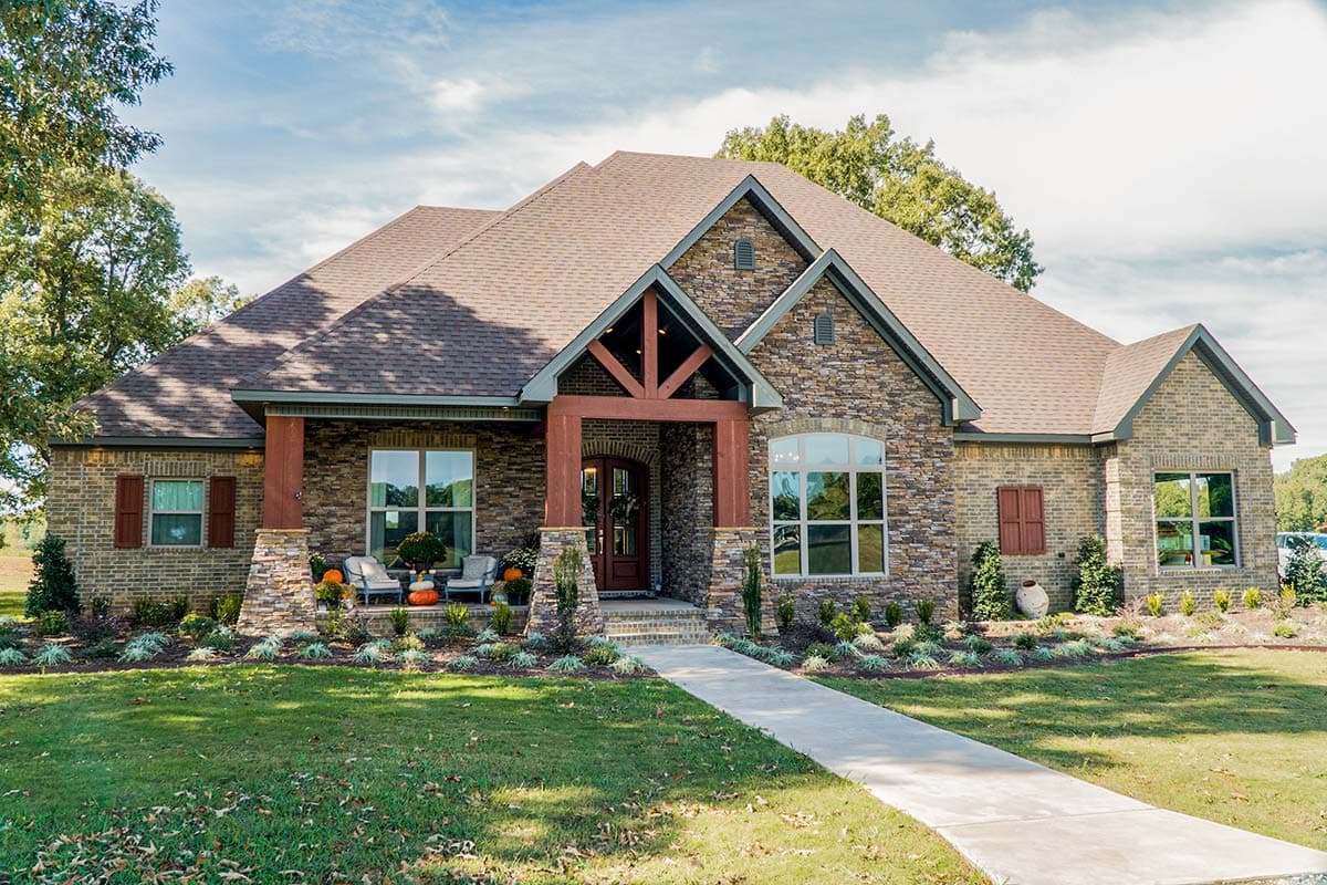 House plan exterior. Ranch-style home with brick and stone veneer, a gable roof, decorative truss over the entry, and a covered porch.