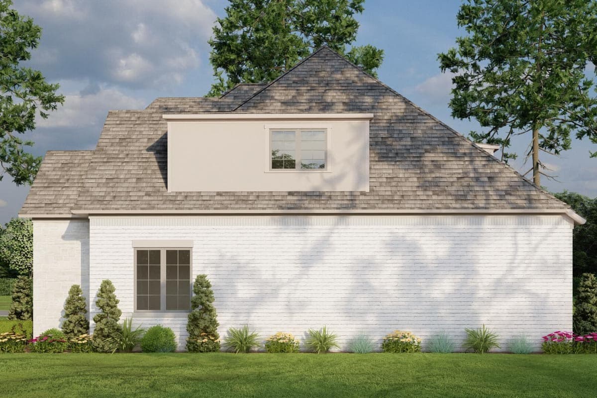 House plan exterior: Brick facade with a dormer window and gambrel rooflines. Shingled roof and manicured landscaping.