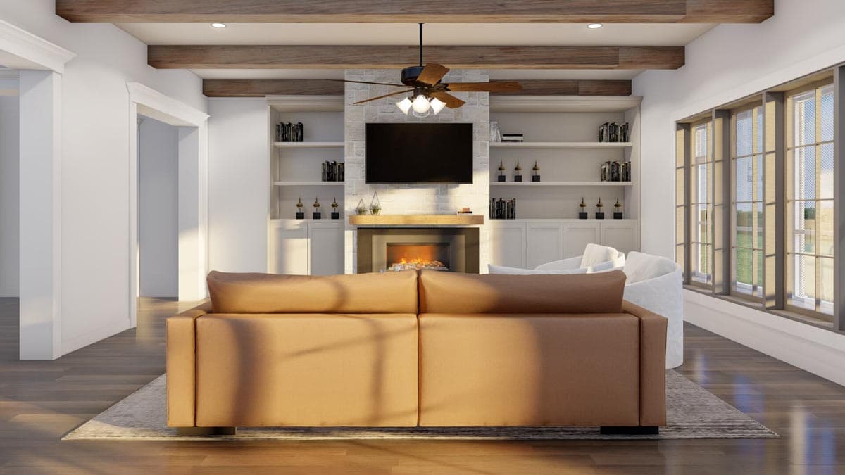 Living room with fireplace, built-in shelving, media console, coffered ceiling, and large windows.